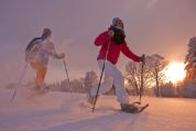 Zwei Schneeschuhwanderer in der tiefstehenden, orangen Sonne Zwei Schneeschuhwanderer in der tiefstehenden, orangen Sonne